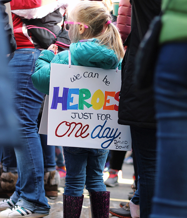Photo: Girl holding sign with saying "We can all be heroes for one day. "-David Bowie